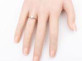a woman ' s hand with a ring on it ' s finger
