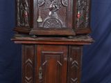 une vieille armoire en bois ornée de sculptures sur le dessus
