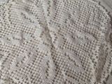 a white doily sitting on a bed next to a pair of scissors