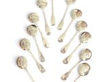 six silver spoons arranged in a circle on a white surface