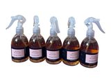 quatre flacons de liquide munis d'un vaporisateur, sur fond blanc