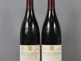 two bottles of wine sitting on top of a table next to each other
