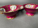 pair of pink and gold porcelain bowls with floral designs on them