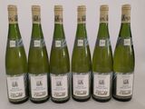 six bouteilles de vin sont alignées sur une table