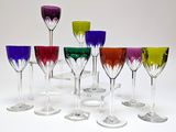 many different colored wine glasses lined up on a table