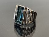 une image d'une bague avec une topaze bleue entourée de diamants