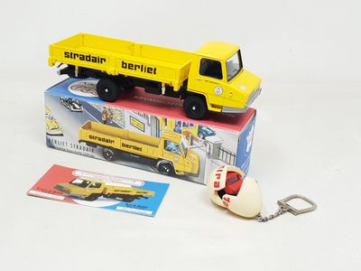 un petit camion jaune avec un porte-clés posé dessus