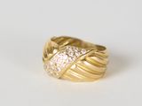 gros plan d'une bague en or avec des diamants sur une surface blanche