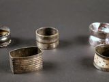 several silver rings sitting on top of a table next to each other