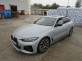 La BMW Z4 est garée sur un parking, avec de nombreux cartons derrière elle.