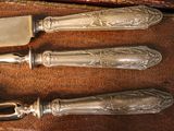 three knives and a knife holder on a wooden table