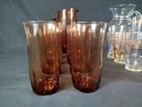 three glasses and a pitcher sitting on a table