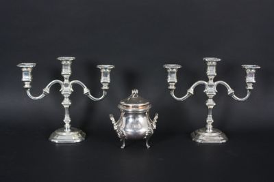 three silver plated candelabs and a silver plated candelab