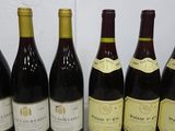 six bottles of wine are lined up in a row on a table