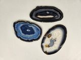 three pieces of blue and white agate sitting on top of a white surface