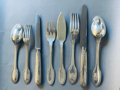 cinq fourchettes, une cuillère et un couteau sur une table