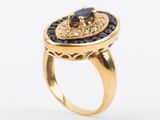 a close up of a gold ring with a black stone