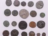 un assortiment de pièces de monnaie romaines antiques exposées sur un support blanc