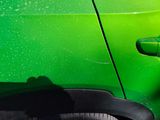 a close up of a green car door with a black handle