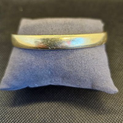 un gros plan d'une bague posée sur un coussin, sur une table