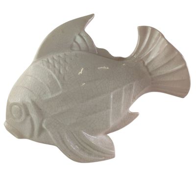 a white ceramic fish that is sitting on a table
