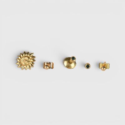 un lot de trois boucles d'oreilles à clous en or ornées d'un motif représentant un soleil