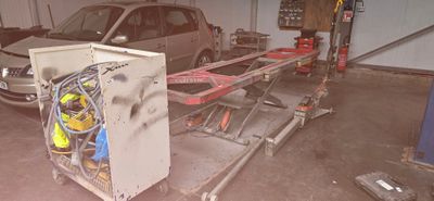 une voiture dans le garage sur laquelle travaille un mécanicien