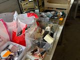 Des boîtes contenant des articles variés sont alignées sur une table dans un atelier.
