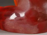 a close up of a red bear statue on a table
