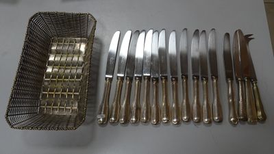 beaucoup de couteaux et un panier rempli de couteaux posés sur une table