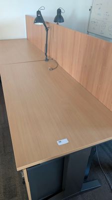 a desk with two chairs and a lamp on top of it