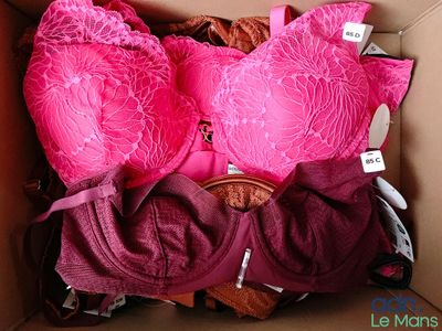 des soutiens-gorge roses dans une boîte en carton, avec des étiquettes de prix