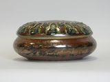 a brown and green bowl sitting on a white surface