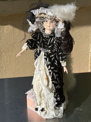 a black and white doll with a white hat and a black and white dress