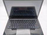 a black laptop with a blue keyboard on a white surface