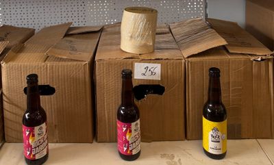 Plusieurs bouteilles de bière sont alignées sur une étagère dans un magasin