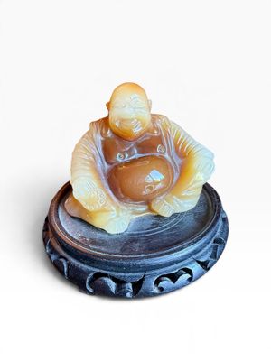 une petite figurine représentant un homme assis sur une assiette