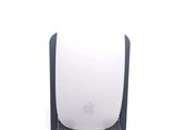 a white apple mouse sitting on top of a black stand