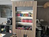 a room with a table, chairs, and a refrigerator in it