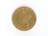 a gold coin on a white surface with a lady ' s head on it