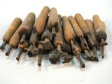 a pile of old wood chisels on a white surface