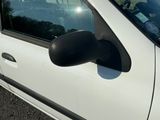 une voiture blanche avec un rétroviseur noir, garée sur le bord de la route