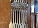 a lot of silverware on a table with a knife and fork