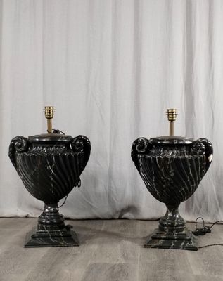 paire de lampes-urnes en marbre noir sur socles, rehaussées de touches dorées