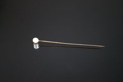 un gros plan d'une aiguille sur laquelle est fixée une boule blanche
