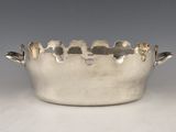 silver plated bowl with handles and handles on a white surface