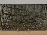 a metal plaque with a picture of a deer in the woods