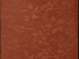 an old book with a red cover sitting on top of a wooden table