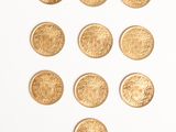 several gold coins are arranged in a triangle on a white surface