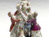une figurine représentant une femme avec des enfants et un chien